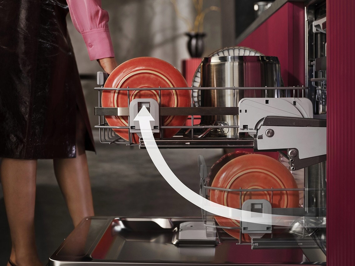 Lähikuva AEG ComfortLift® -toiminnosta, jossa astianpesukoneen alempi kori nostetaan mukavalle työkorkeudelle modernissa punaisessa keittiössä.